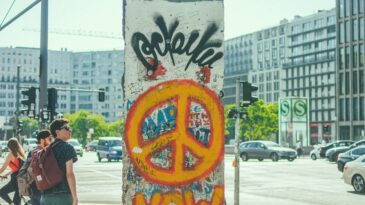 orange peace sign on a slice of the Berlin Wall in modern day Berlin